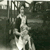 Baby on knee in front of hut at holiday camp.jpg